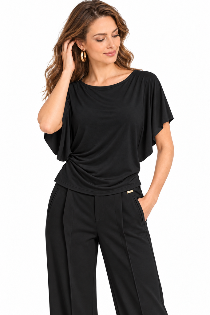 Elegantes schwarzes Outfit vor weißem Hintergrund.webp